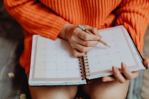 Therapist using a paper planner to organize client appointments and schedules.