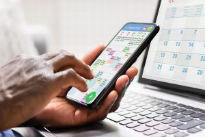 Managing appointments and meetings using a digital calendar on phone and laptop.